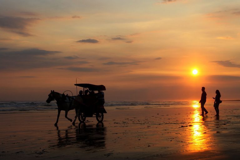 Wisatawan menikmati matahari terbenam di Pantai  